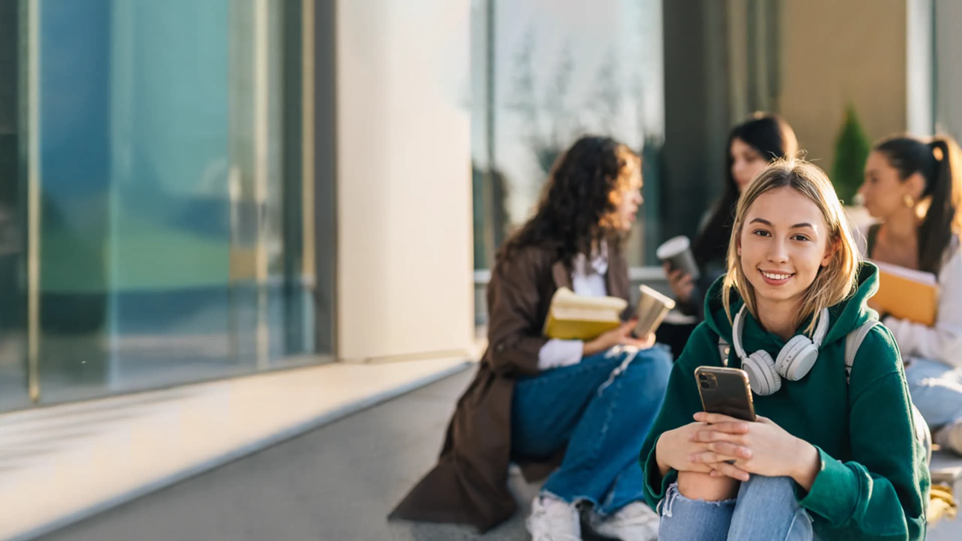 Symbolbild Jugendkonto mit Mädchen mit Kopfhörern und Handy in der Hand
