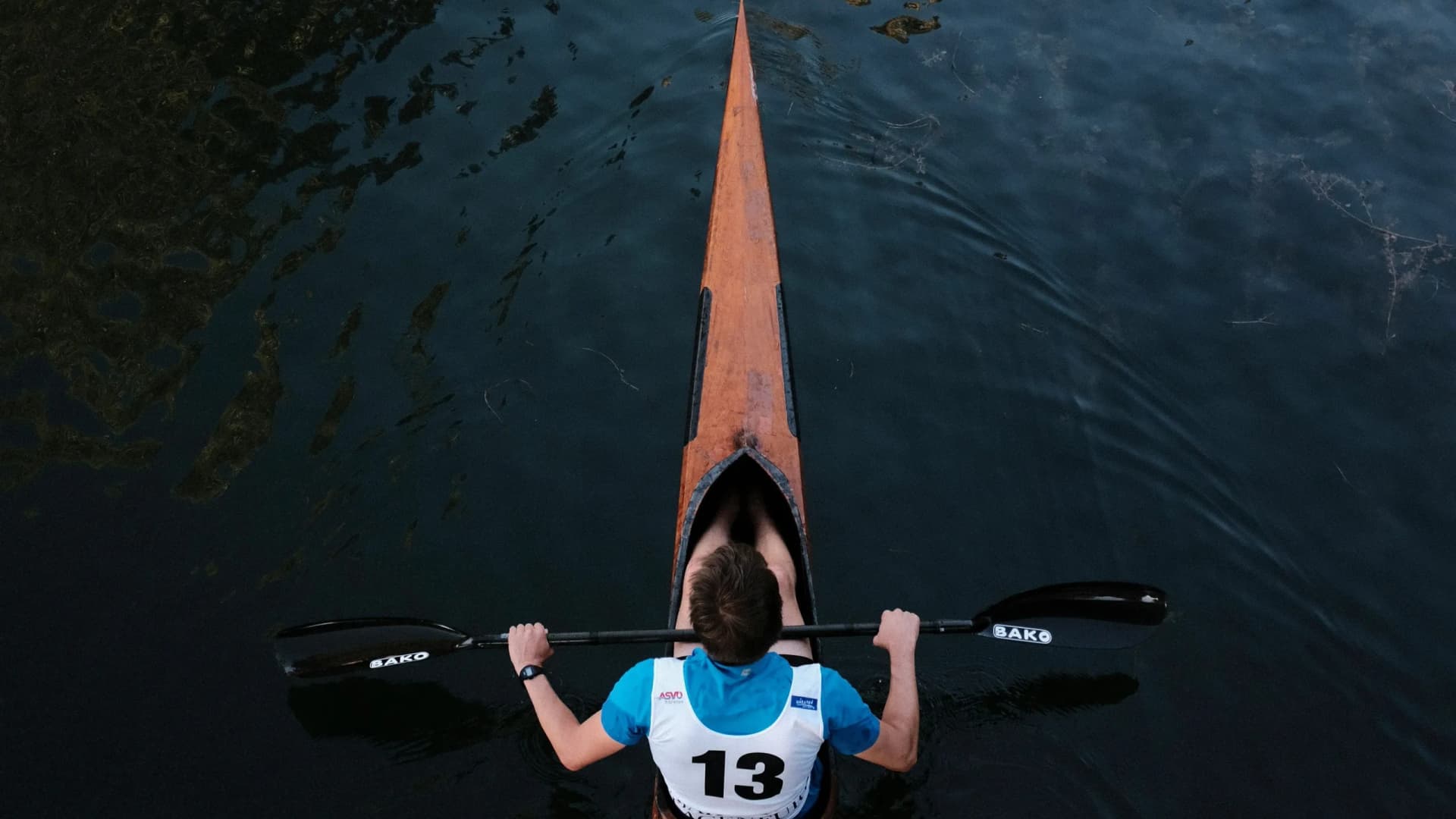 Mann fährt Kanu auf einem See als Symbolbild