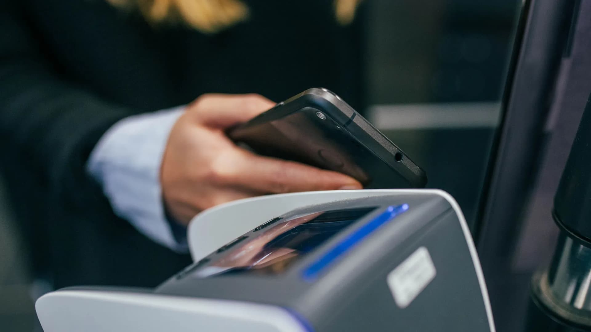 Handy-Zahlung bei Gerät an der Kasse als Symboldbild für Wallet Pay App der Bank Burgenland
