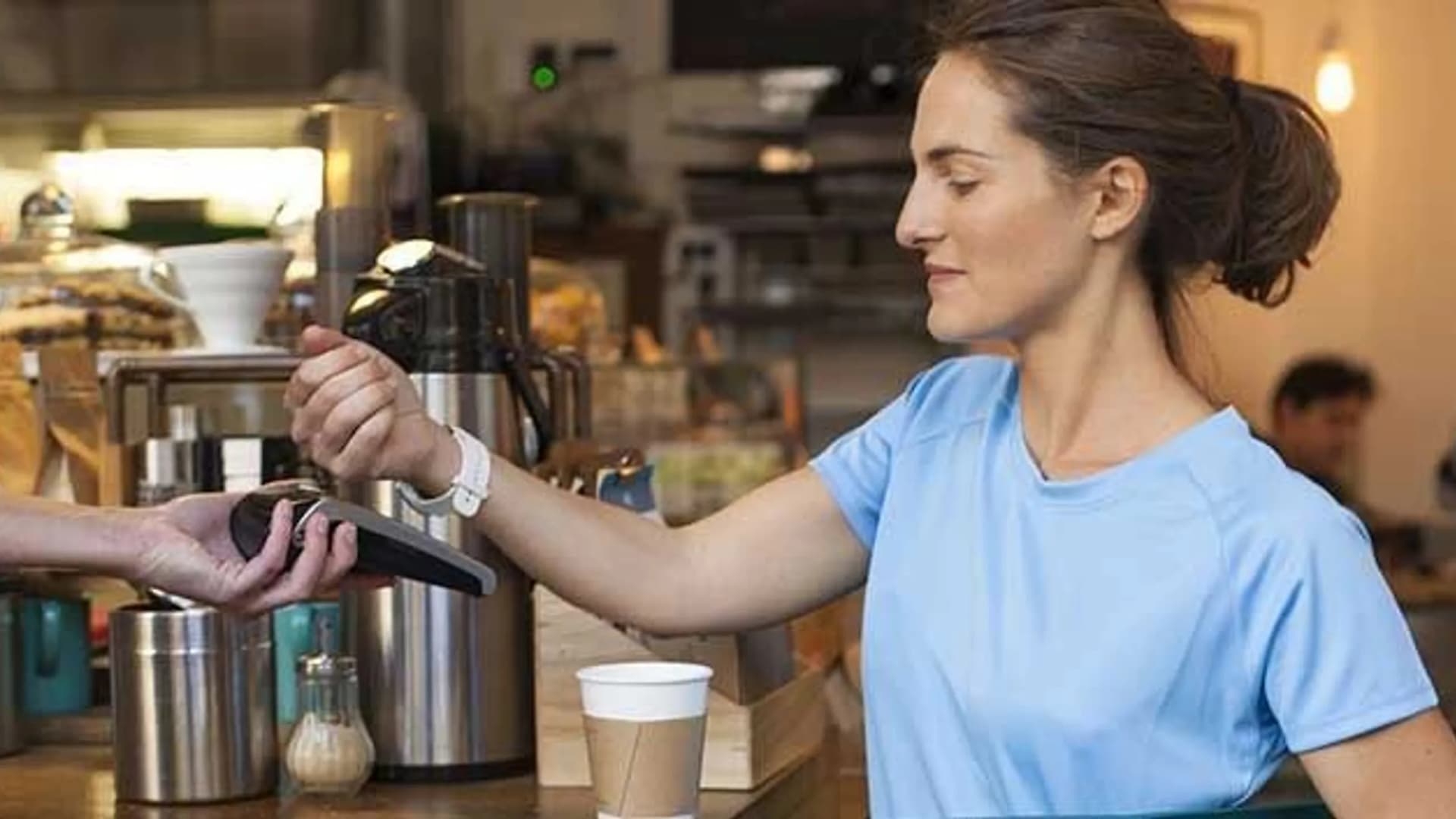 Frau zahlt mit Smartwatch an der Kassa. Symbolbild für Garmin Pay bei der Bank Burgenland