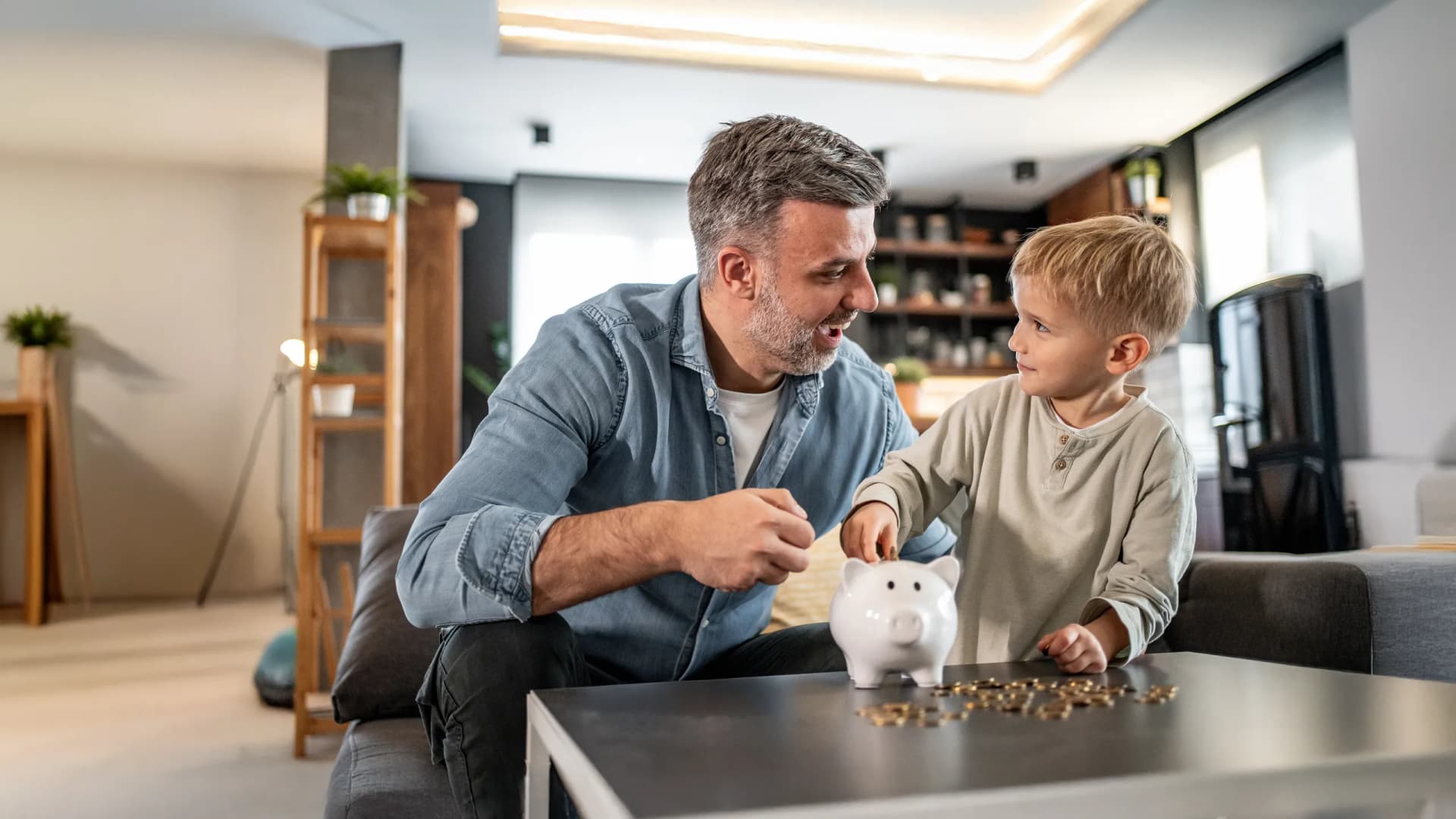 Vater und Sohn zahlen in Sparschwein ein