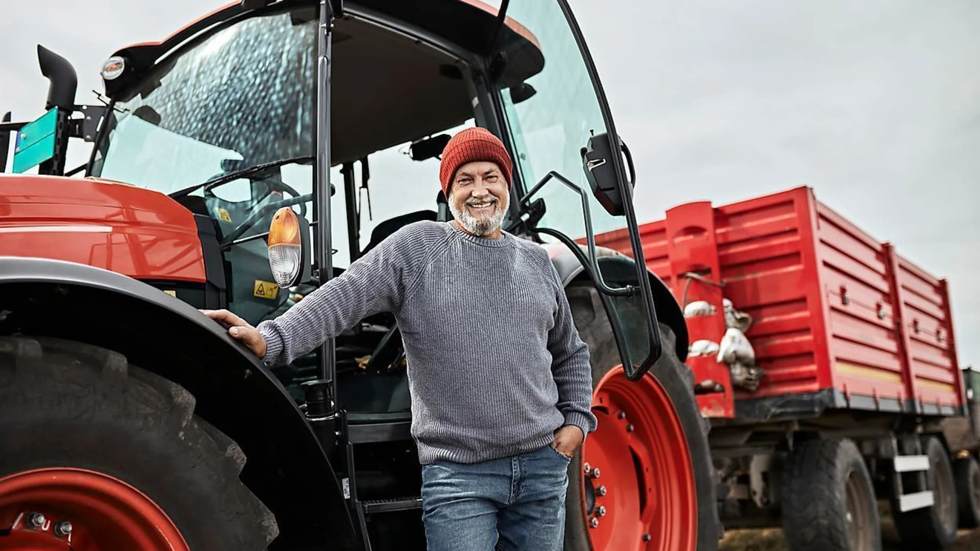 Mann mit rotem Traktor als Symbolbild für Leasing für Ihr Unternehmen - mit den Expertinnen und Experten der Bank Burgenland und Bank Burgenland Kärnten
