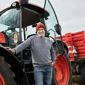 Mann mit rotem Traktor als Symbolbild für Leasing für Ihr Unternehmen - mit den Expertinnen und Experten der Bank Burgenland und Bank Burgenland Kärnten