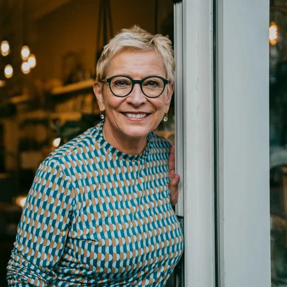 Frau blickt in Kamera als Symbolbild für "Bei Fragen zu unserem Online Banking stehen wir jederzeit zur Verfügung".
