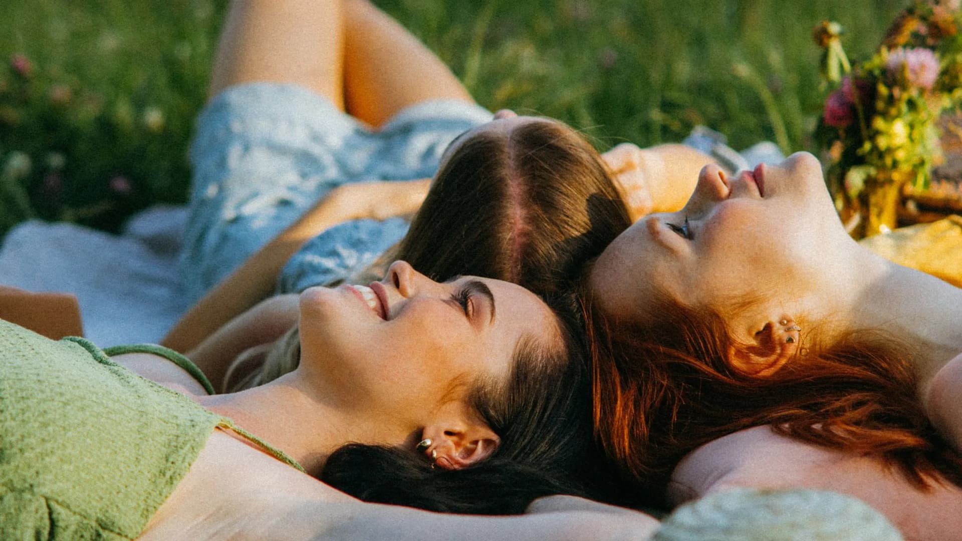 Blog Konsum im Sommer: Frauen liegen auf Picknickdecke im Gras